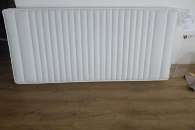 un radiateur blanc posé à même le sol près d'un mur
