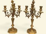 pair of antique brass candelabs on pedestals on a white background