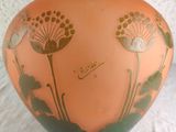 an orange vase with black and gold designs on it