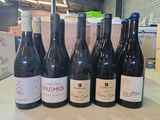 Plusieurs bouteilles de vin sont alignées sur une table dans un entrepôt