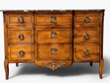 a wooden chest of drawers with a marble top