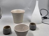 trois tasses et un vase posés sur une table