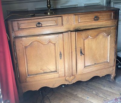 a wooden cabinet with two doors and a lamp on top of it