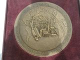 une médaille d'or sur laquelle est représenté un train