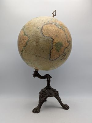 a small statue of a man standing on top of a globe