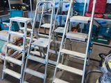 de nombreuses échelles empilées dans un garage