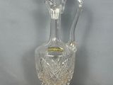 une image représentant un vase en verre transparent posé sur un socle en bois