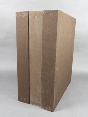deux boîtes en carton sont empilées l'une sur l'autre sur une surface blanche