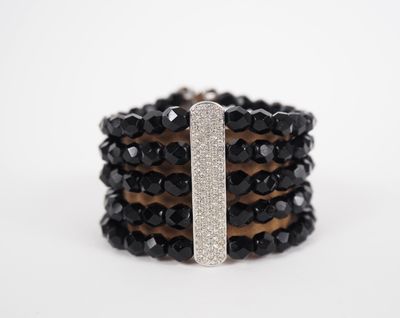 a close up of a stack of black and white bracelets