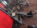 a lot of machines in a gym room with red walls