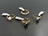 trois paires de bagues en perles et en or sur un fond noir