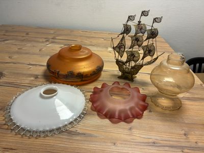 three vases sitting on a wooden table with a ship in the background