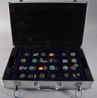 a silver case with coins in it on a white surface