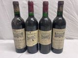 four bottles of wine are lined up on a table