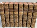 six vieux livres alignés sur une surface blanche