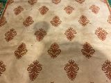 an area rug with a green border and red and white designs on it
