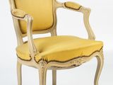 une chaise jaune posée sur un sol blanc, à côté d'un mur blanc