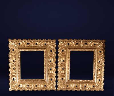 a pair of antique gold picture frames on a blue background
