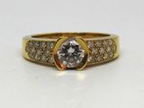 gros plan d'une bague en or avec un diamant au centre