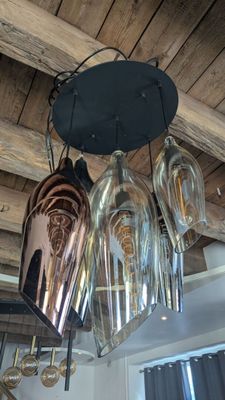 many wine glasses hanging from the ceiling in this room