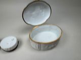 a white bowl with a gold rim and a white container with a lid
