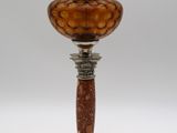 une lampe ancienne en métal argenté, avec un abat-jour en verre marron