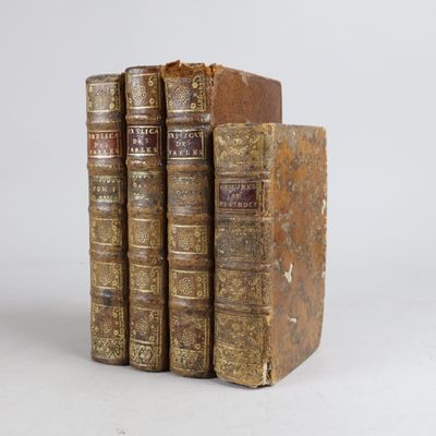 trois vieux livres posés l'un sur l'autre sur une surface blanche