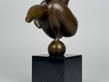 sculpture en bronze représentant un oiseau, posée sur un socle en marbre noir