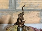 an elephant on top of a brass plate on a table