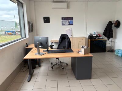 un bureau avec un ordinateur portable et un écran dans une pièce