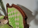 a green chair with a checkered upholstered seat