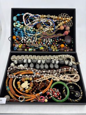 une boîte noire remplie de bijoux divers posée sur une table