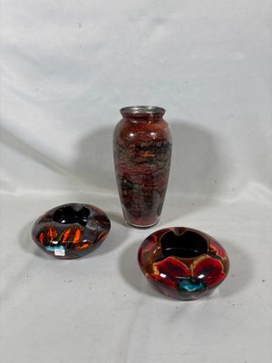 trois vases posés l'un à côté de l'autre sur une surface blanche