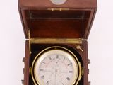 clock in a wooden box on a white surface with a white background