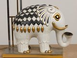 a white and gold elephant statue on a wooden table