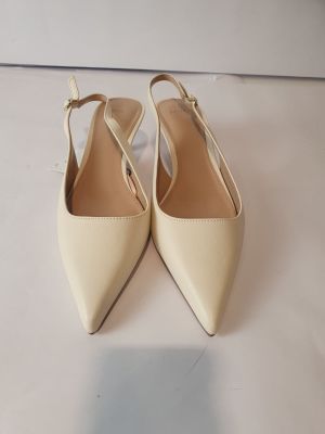 un gros plan sur une paire de chaussures beiges posées sur une surface blanche