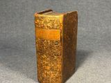 an old book sitting on top of a table next to a gray background