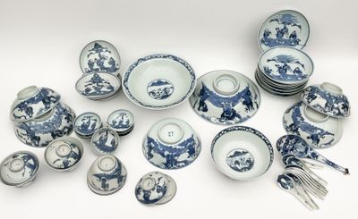many blue and white plates and bowls and utensils on the table