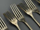 cinq fourchettes posées les unes à côté des autres sur une table