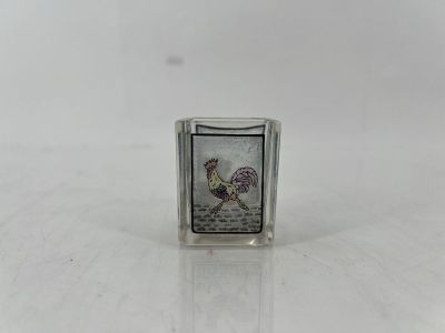 une image représentant un petit bloc de verre orné d'un coq