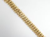 a close up of a gold bracelet on a white surface