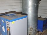 a large metal tank sitting next to a blue machine