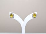 paire de boucles d'oreilles à clous en saphir jaune et diamants, présentées sur un socle blanc