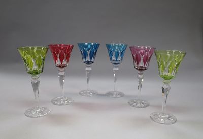 several different colored wine glasses are lined up in a row