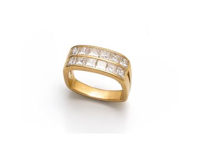 une bague en or sertie de diamants taille princesse sur fond blanc