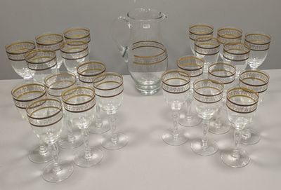bottles and glasses are lined up on a table with a pitcher