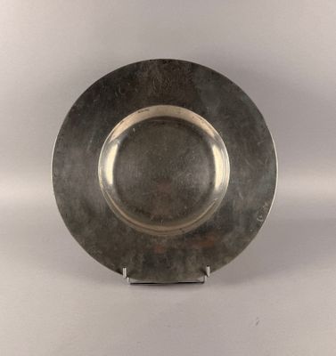 a silver plate on a stand on a white surface