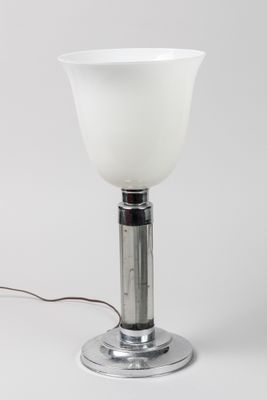 a white glass table lamp with a metal base and a white glass shade