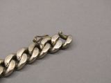 une photo d'un bracelet en argent posé sur une surface grise