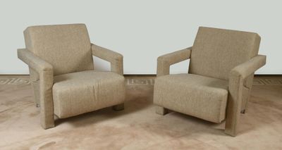 pair of beige upholstered chairs in a room with a rug